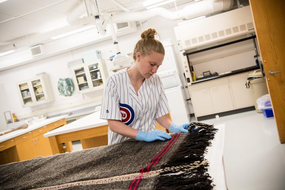 A Beloit student studies a textile from the collection in the Logan Museum of Anthropology.