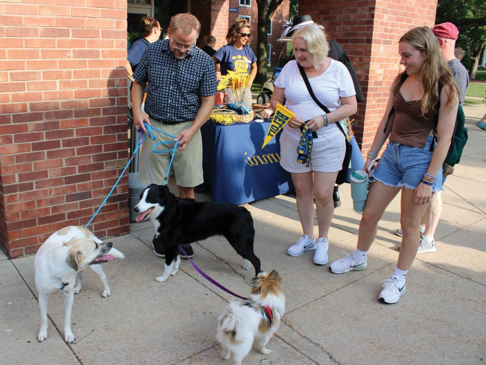 埃里克和小狗们在迎新日问候学生和他们的家人.